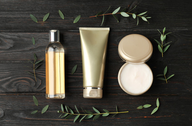 Photo of Flat lay composition with cosmetic products on black wooden table