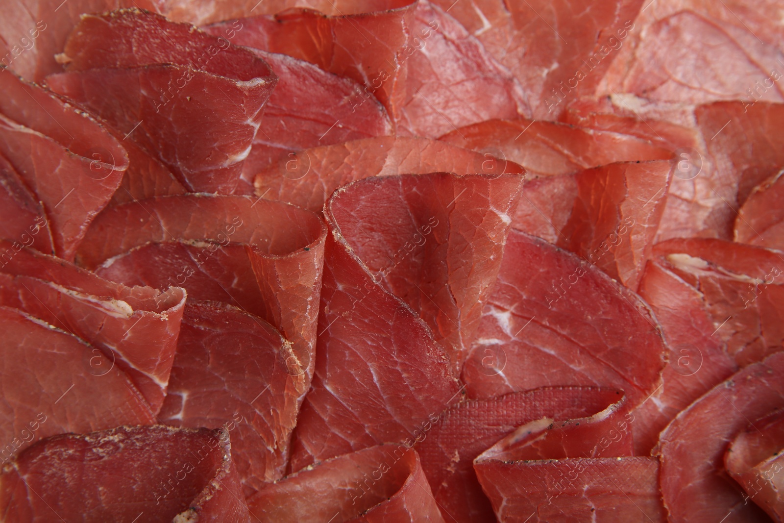 Photo of Slices of tasty bresaola as background, top view