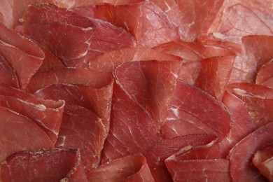 Photo of Slices of tasty bresaola as background, top view