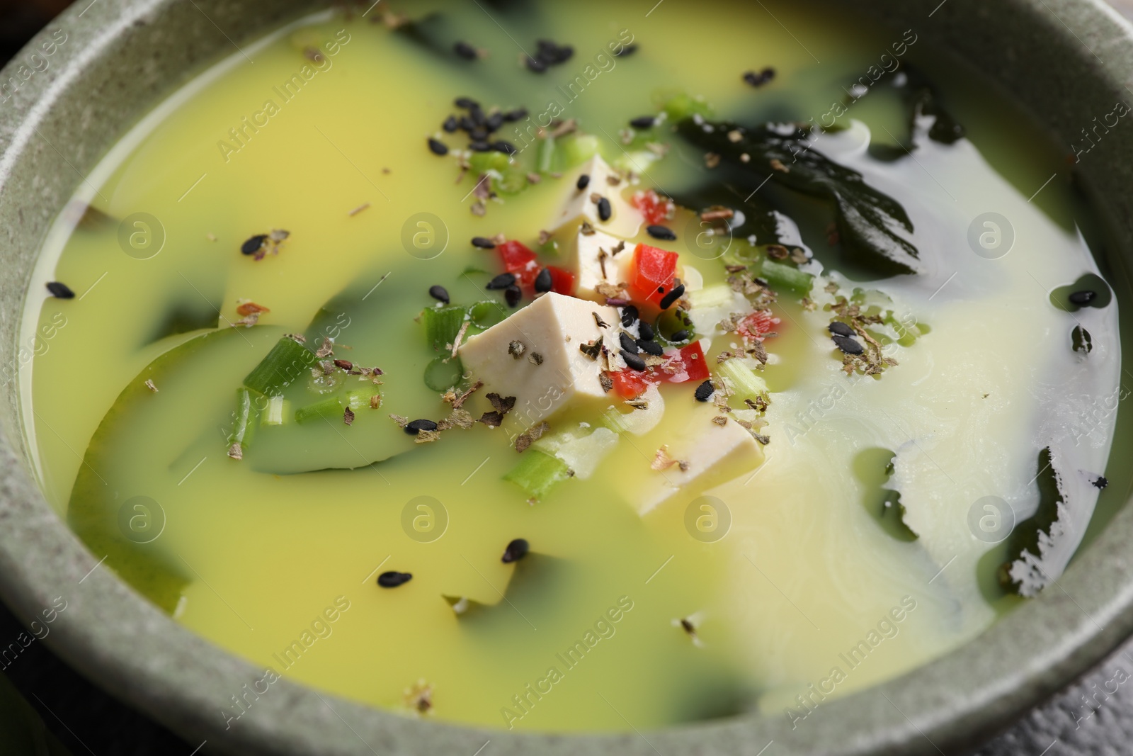 Photo of Bowl of delicious miso soup with tofu, closeup