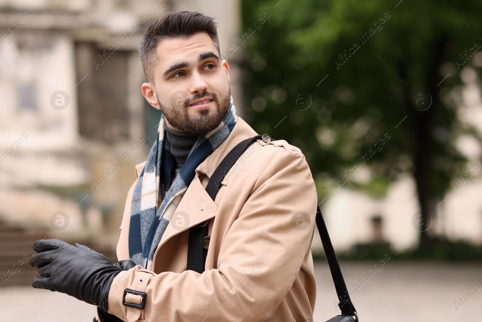 Photo of Smiling man in warm scarf on city street