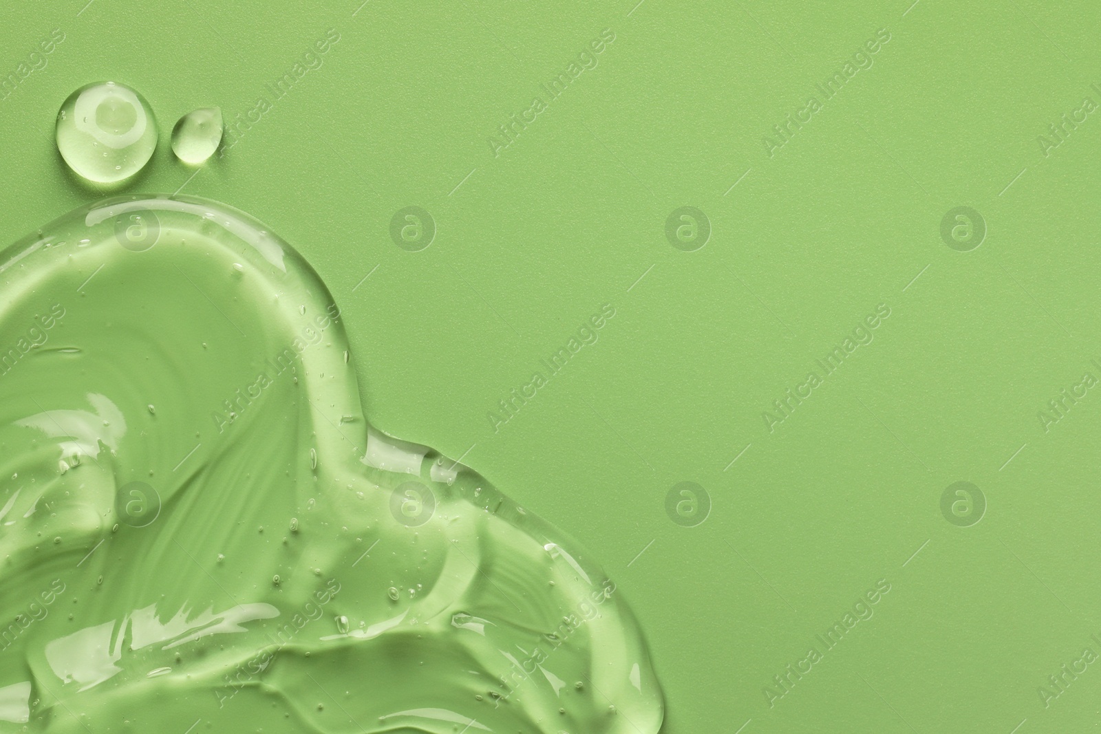Photo of Clear cosmetic gel on light green background, top view. Space for text
