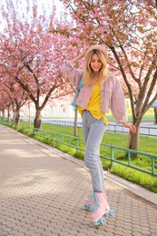 Photo of Young woman roller skating in spring park