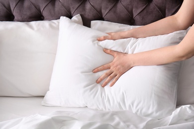 Young woman making bed, closeup