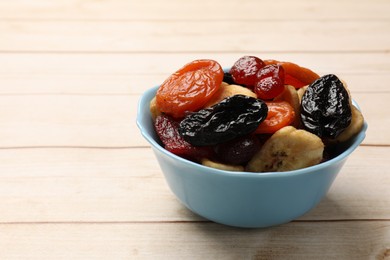 Mix of delicious dried fruits on white wooden table, closeup. Space for text