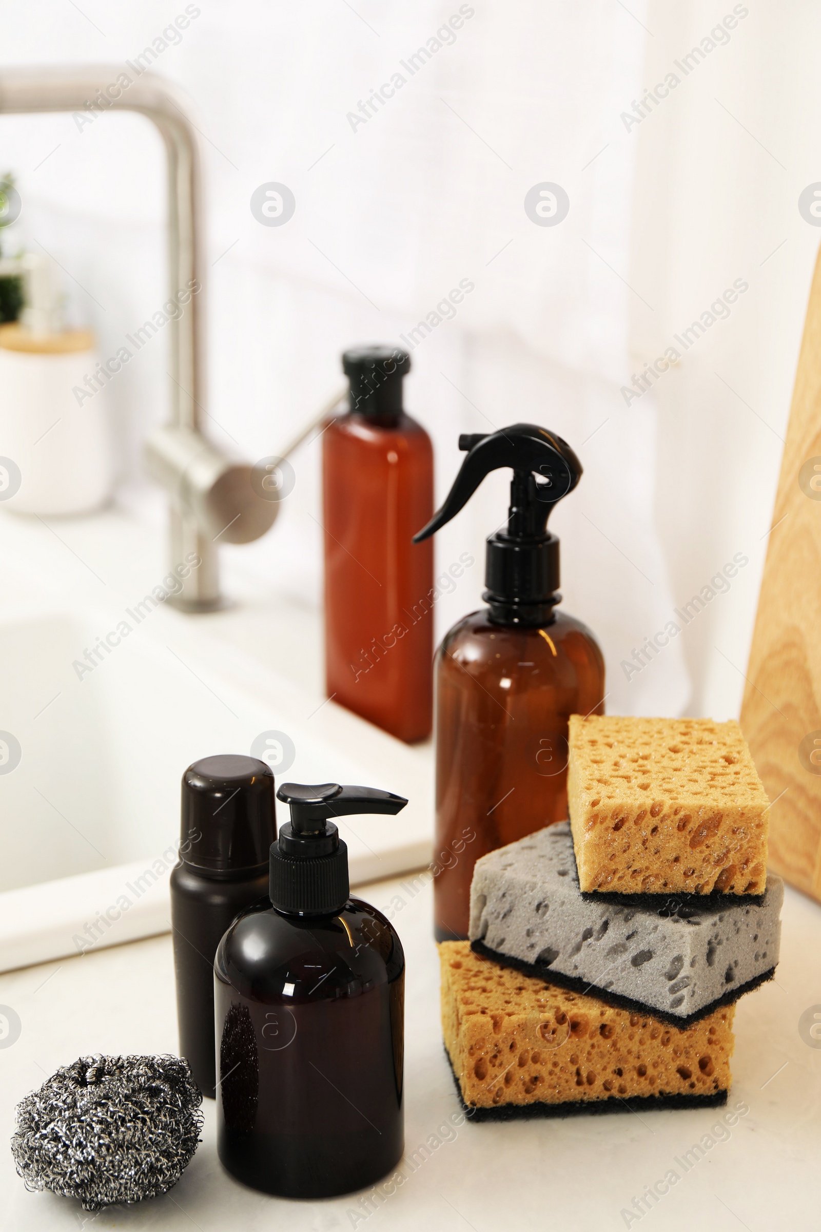 Photo of Different cleaning supplies on countertop in kitchen