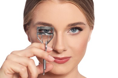 Young woman using eyelash curler on white background, closeup
