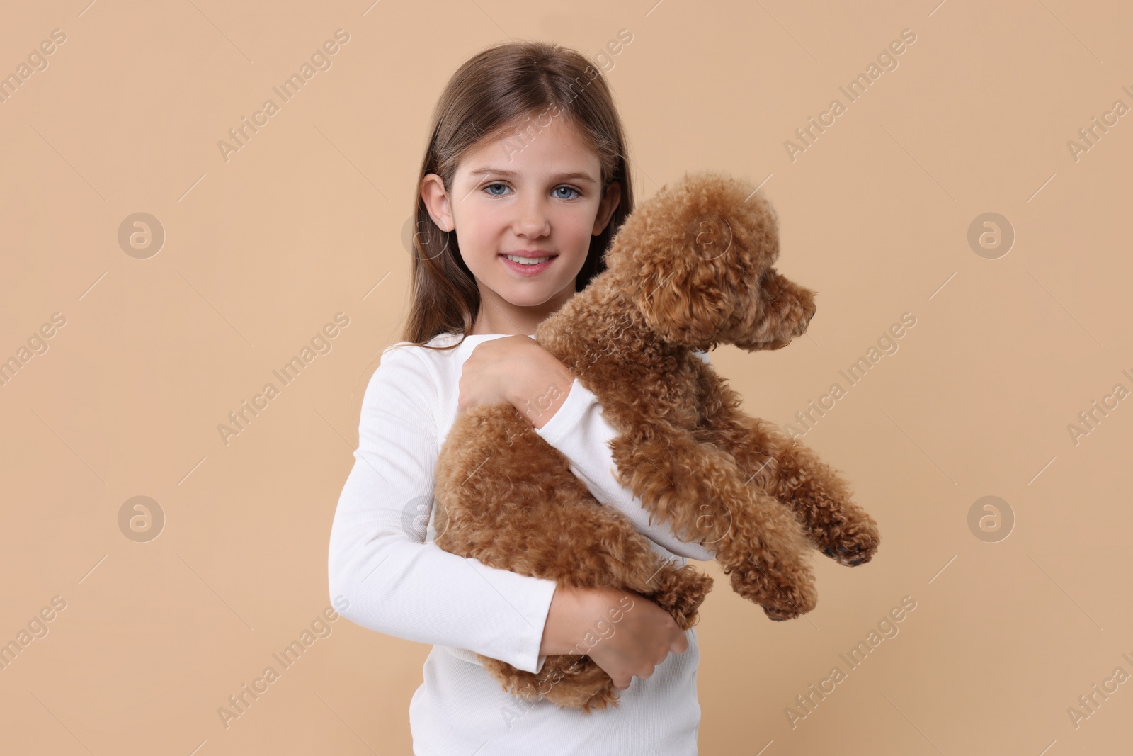 Photo of Little child with cute puppy on beige background. Lovely pet