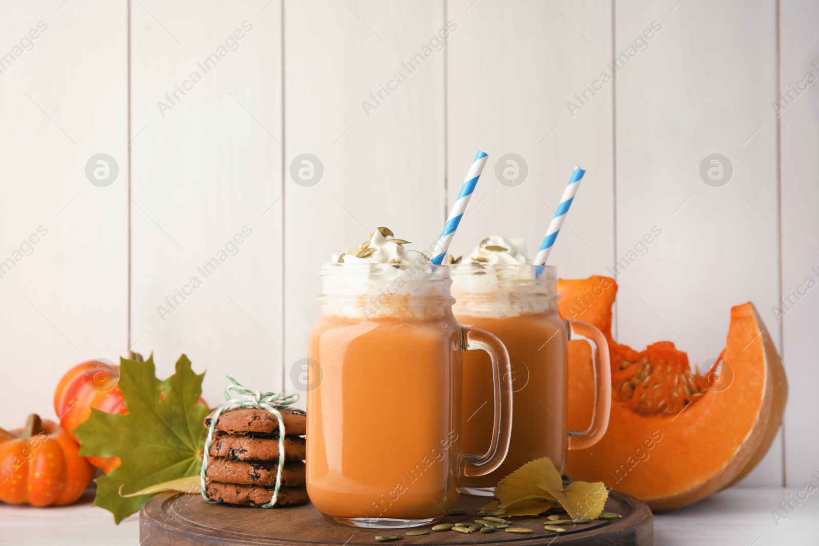 Photo of Composition with pumpkin spice latte in mason jars on table