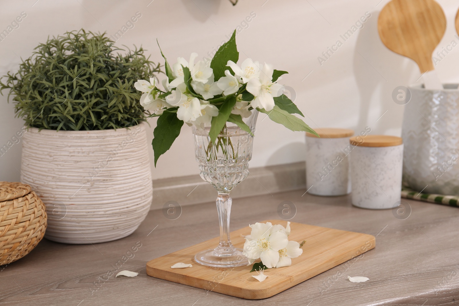 Photo of Beautiful jasmine flowers on wooden table indoors