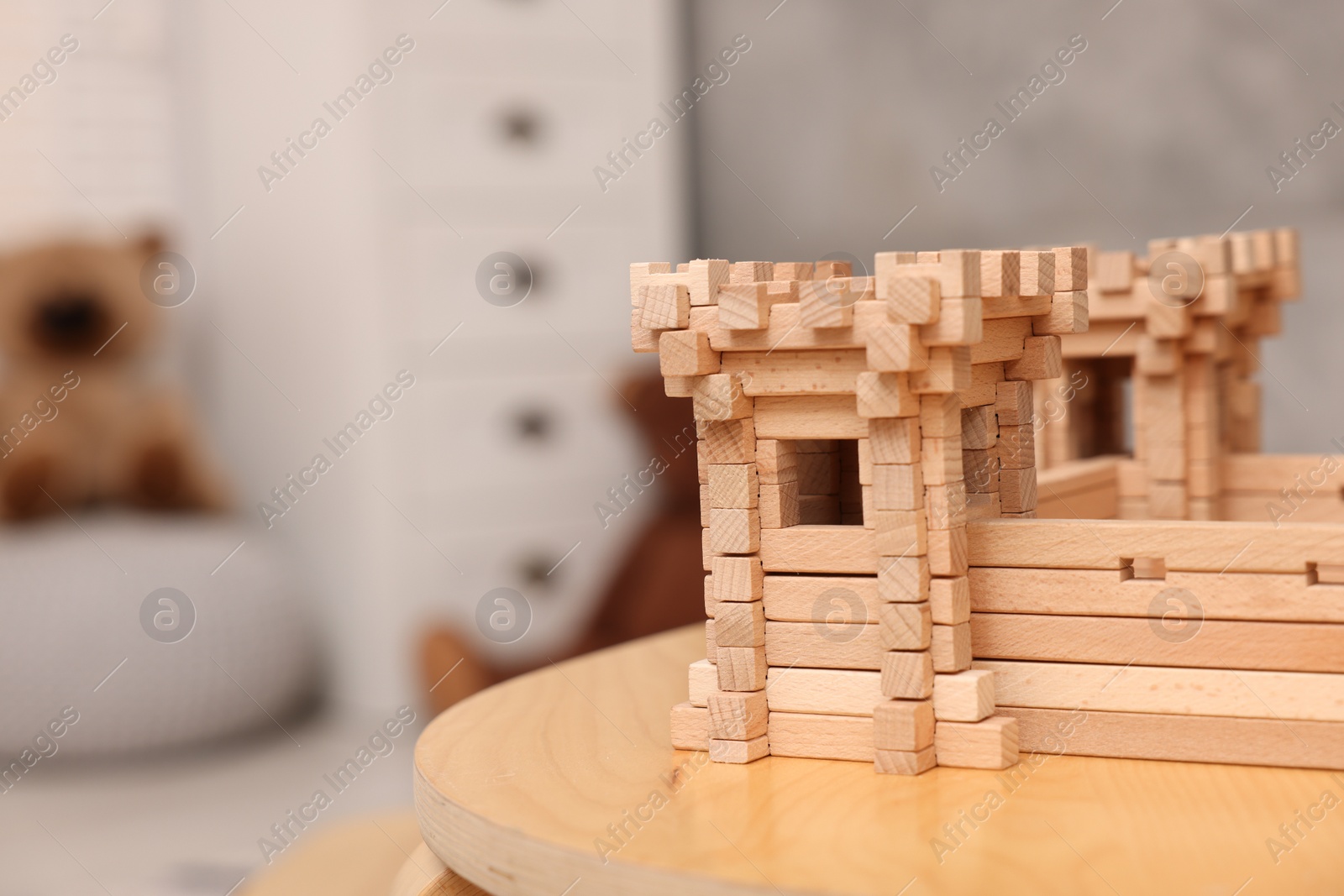 Photo of Wooden fortress on table indoors, space for text. Children's toy