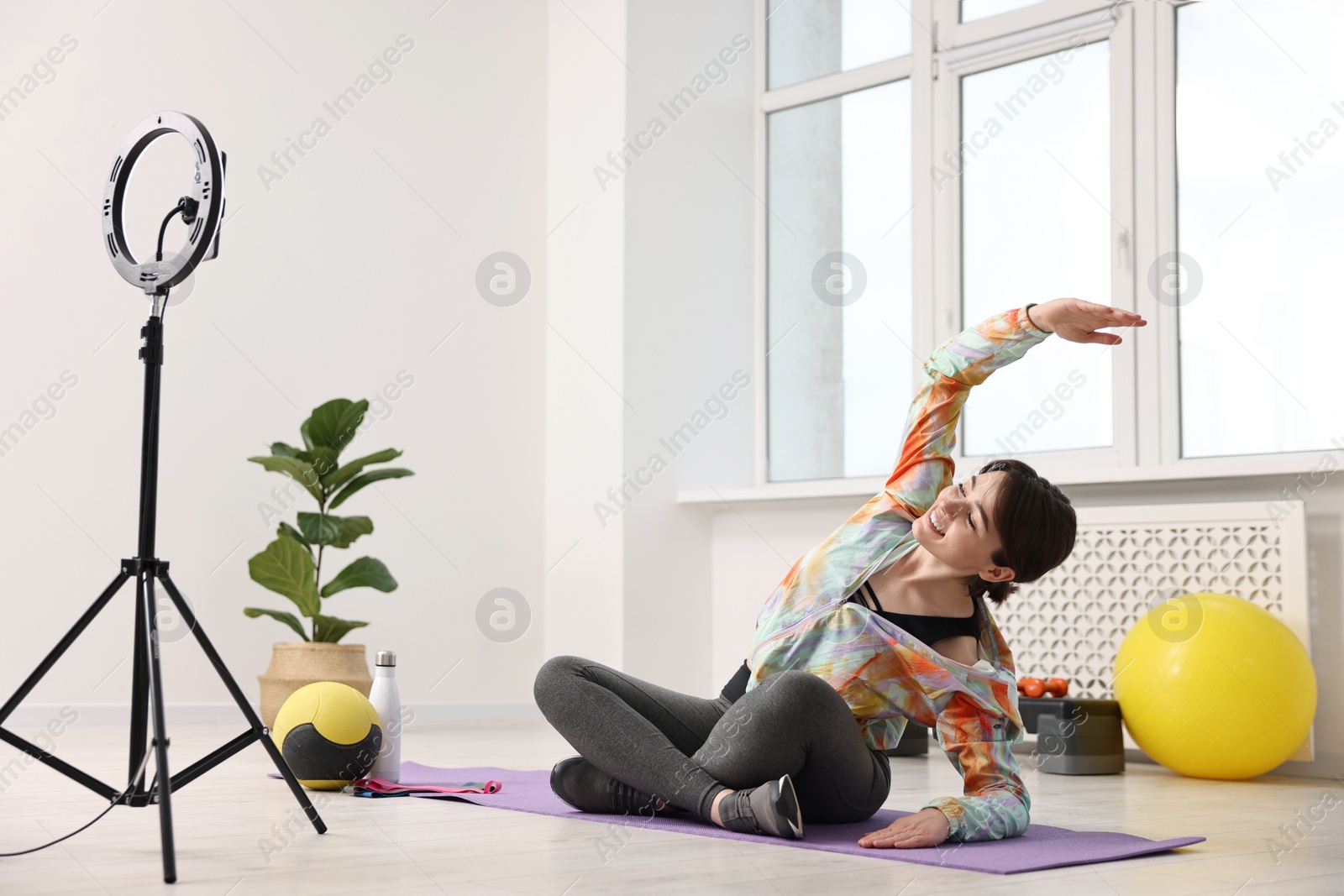 Photo of Happy sports blogger streaming online fitness lesson at home