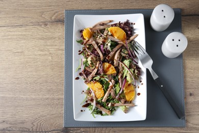 Photo of Delicious salad with beef tongue, orange, onion and fork served on wooden table, flat lay. Space for text