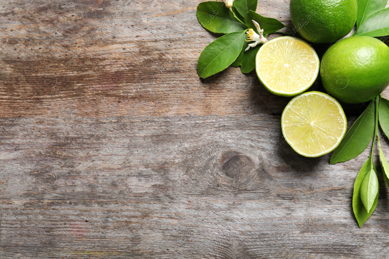 Photo of Composition with fresh ripe limes on wooden background, top view