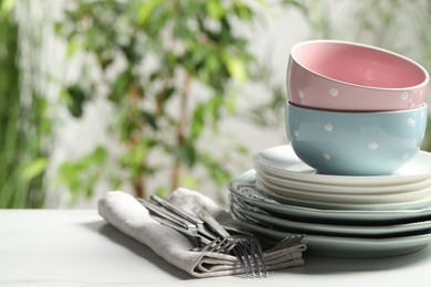 Photo of Beautiful ceramic dishware and cutlery on white table outdoors, space for text