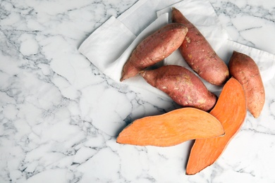 Photo of Flat lay composition with sweet potatoes and space for text on marble background