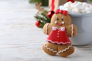 Photo of Gingerbread girl white wooden table, closeup. Space for text