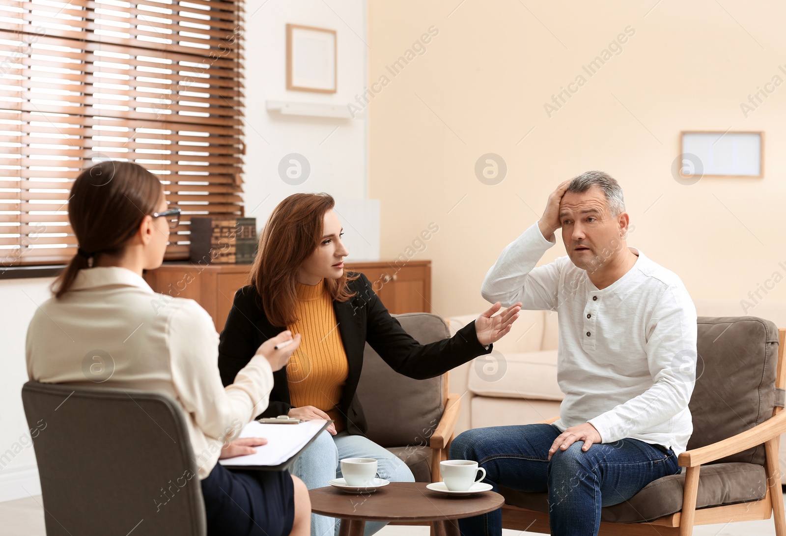 Photo of Psychotherapist working with couple in office. Family counselling