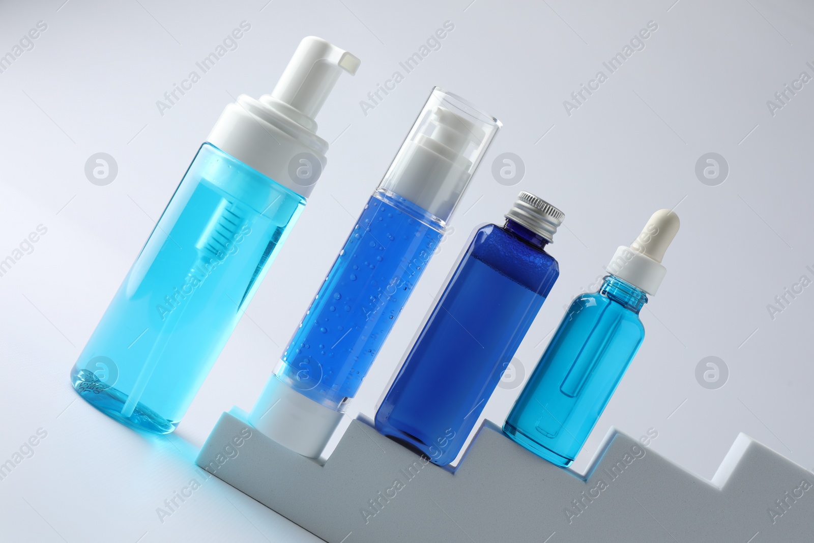 Photo of Set of luxury cosmetic products on stairs against white background