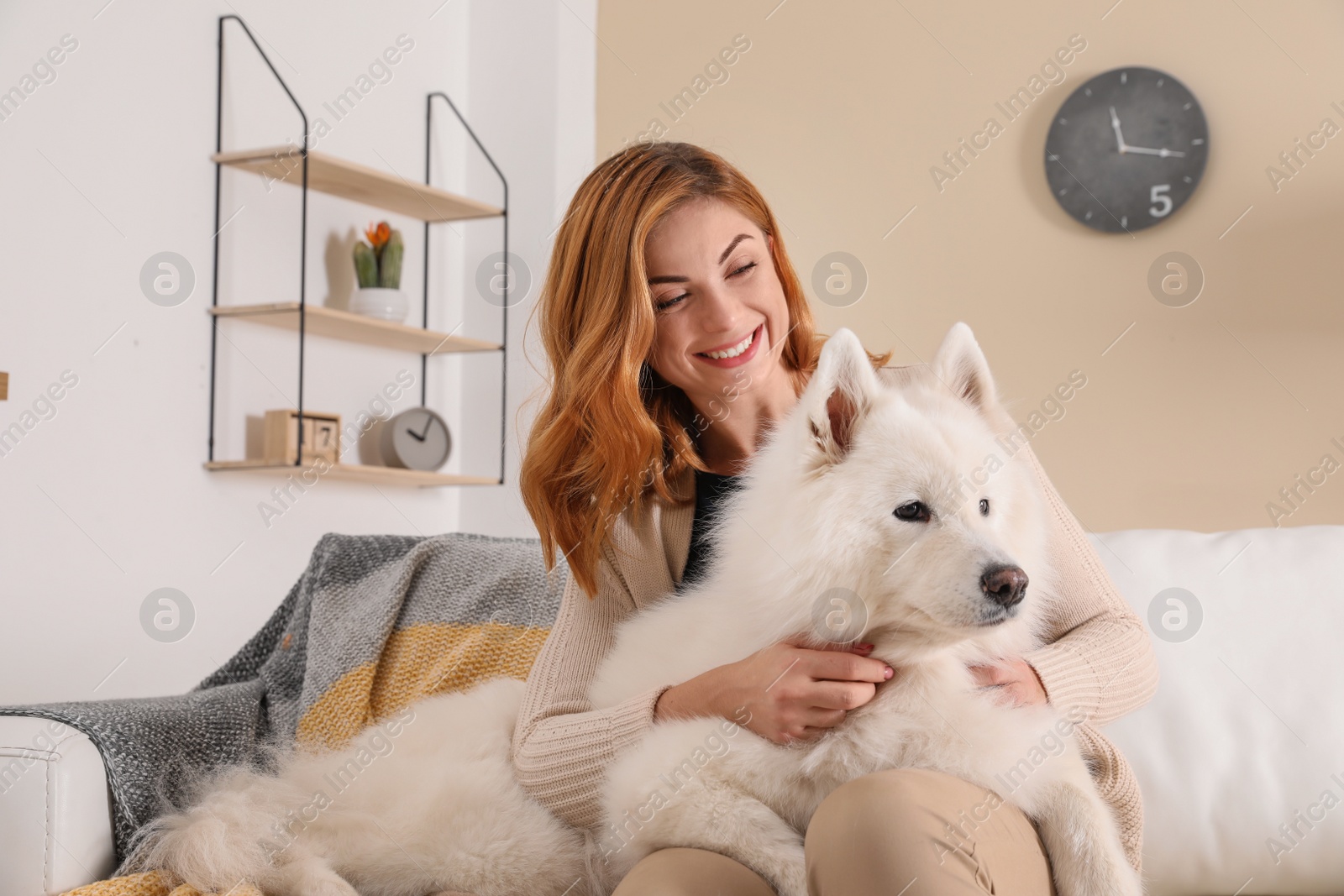 Photo of Beautiful woman with her dog sitting on sofa at home