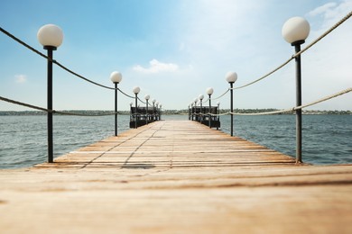 Photo of Beautiful river scene with wooden pier on sunny day
