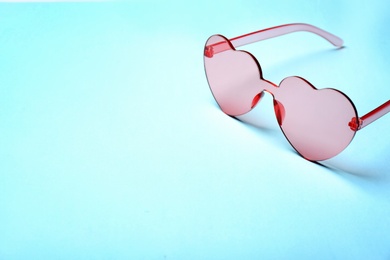 Photo of Stylish heart shaped glasses on color background. Space for text
