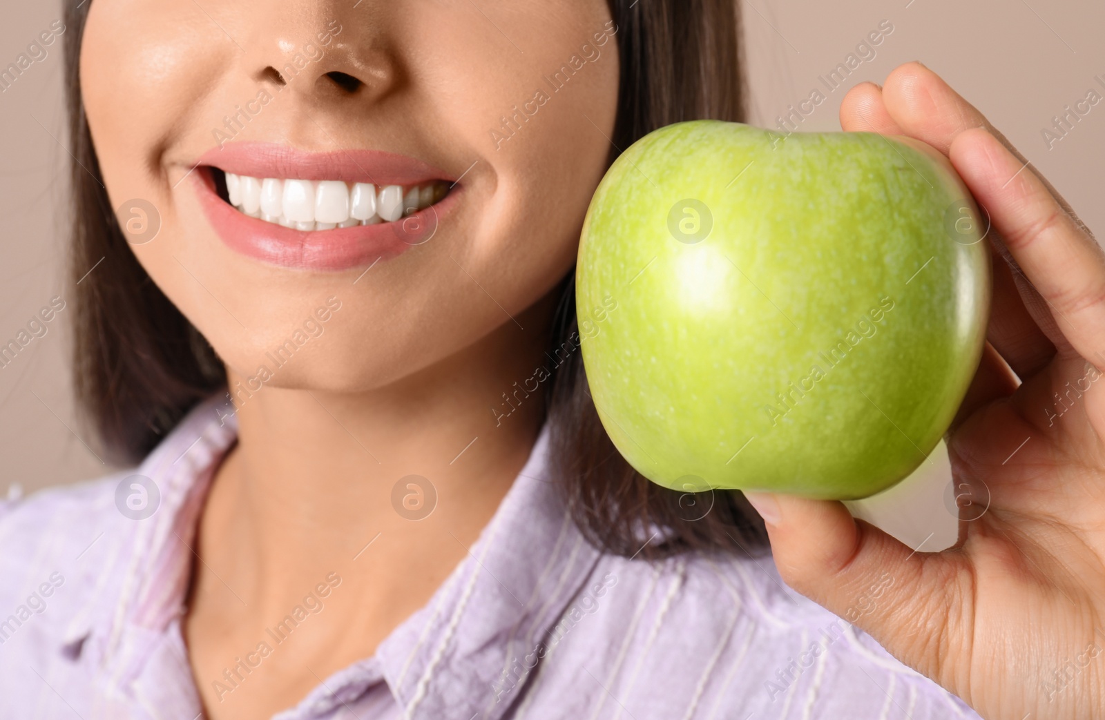 Photo of Young woman with healthy teeth and apple on color background, closeup