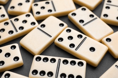 Photo of Classic domino tiles on black background, closeup