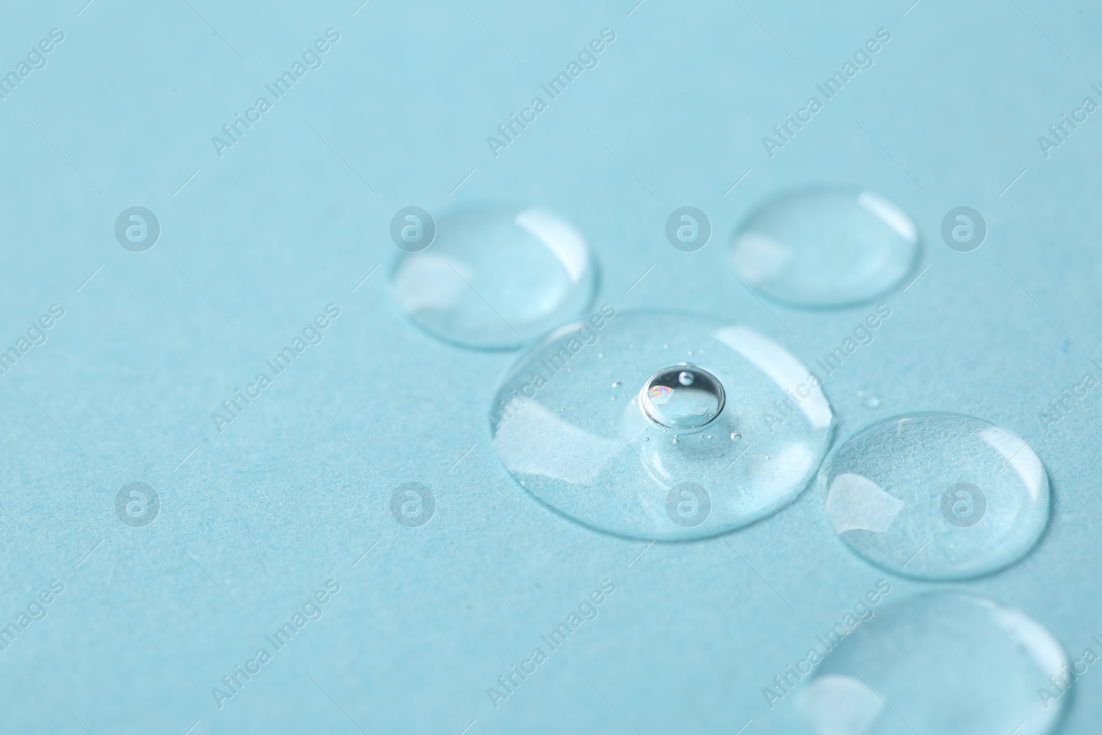 Photo of Samples of cosmetic serum on light blue background, closeup. Space for text