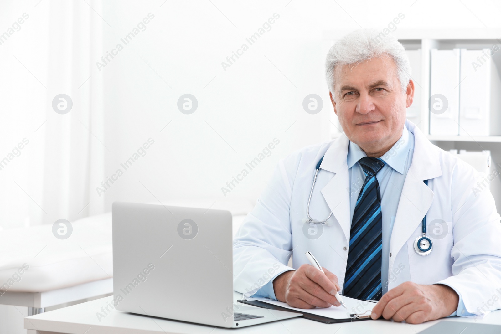 Photo of Portrait of senior doctor in white coat at workplace