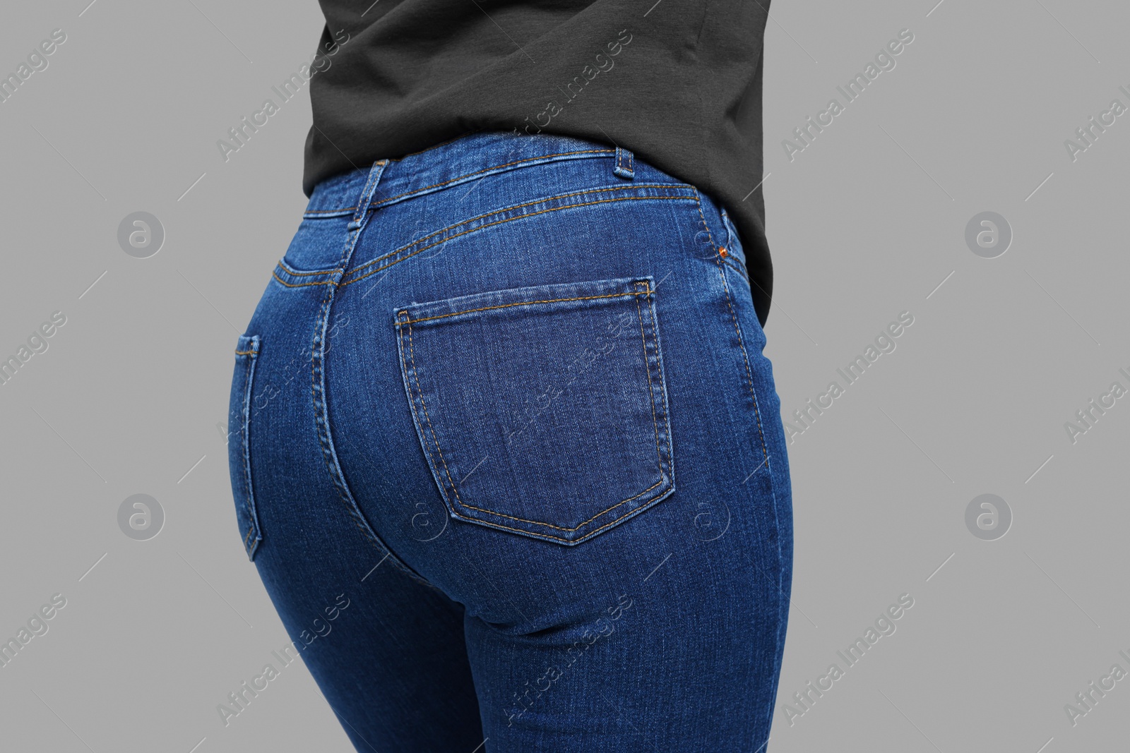 Photo of Woman in stylish jeans on grey background, closeup