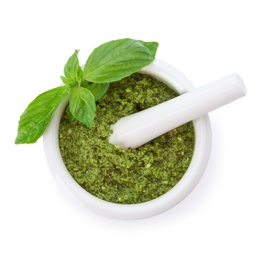 Mortar of tasty pesto sauce with basil leaves and pestle isolated on white, top view