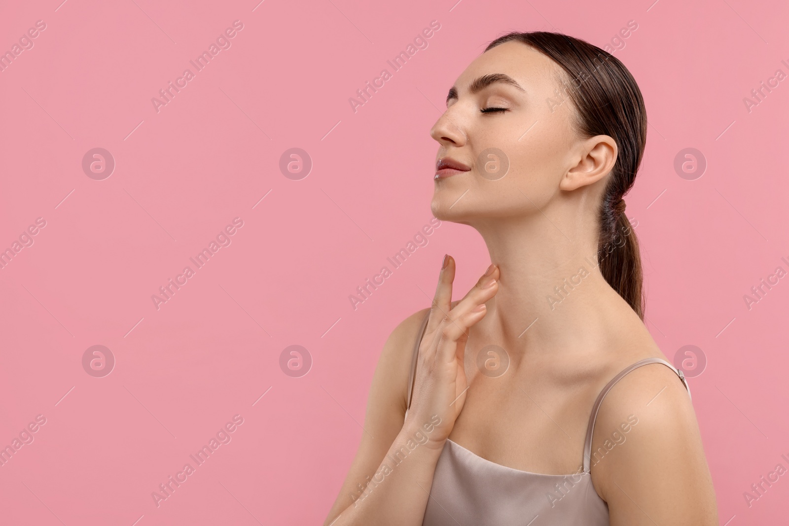 Photo of Beautiful woman touching her neck on pink background. Space for text