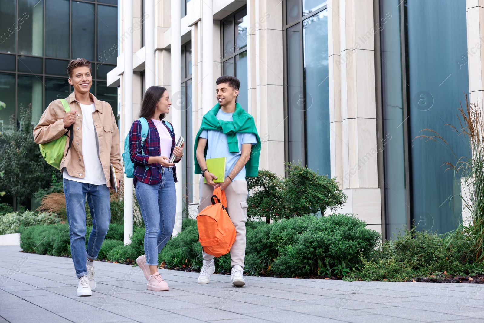 Photo of Group of happy students walking together outdoors