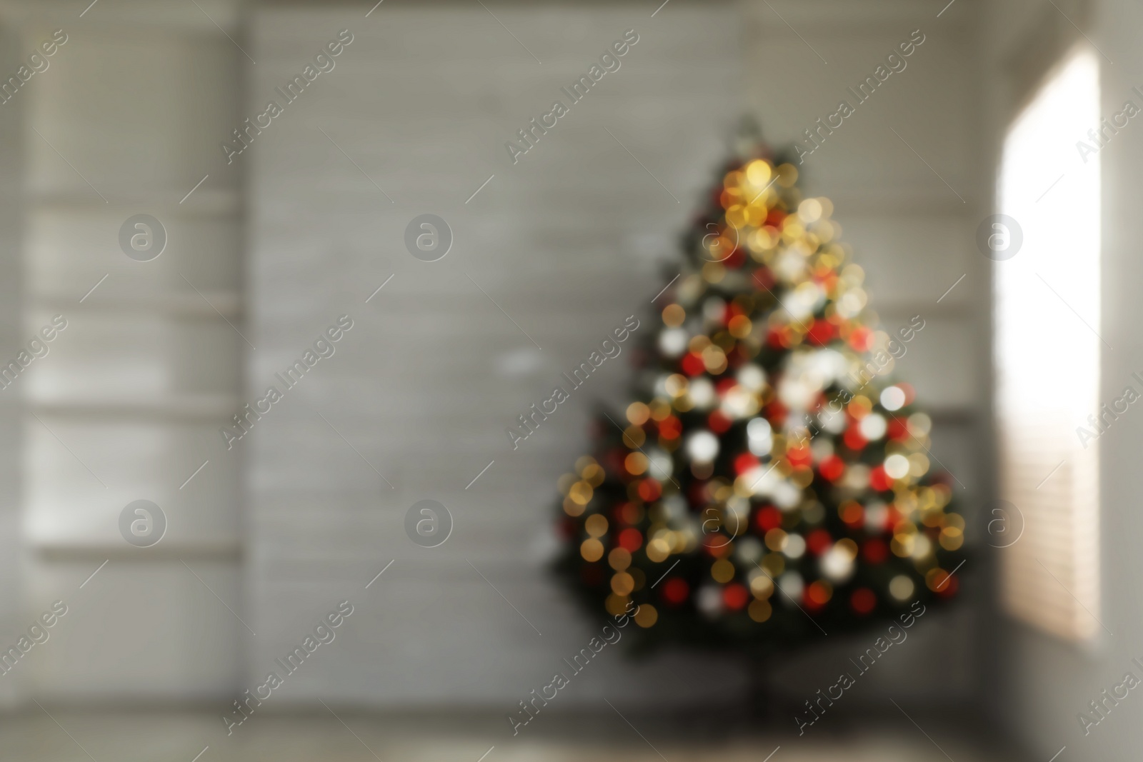 Photo of Blurred view of beautifully decorated Christmas tree in empty room, space for text. Bokeh effect