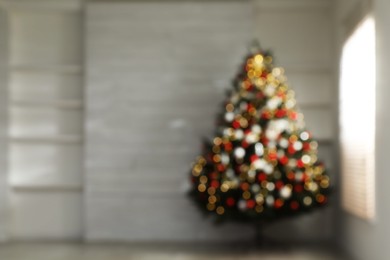 Photo of Blurred view of beautifully decorated Christmas tree in empty room, space for text. Bokeh effect