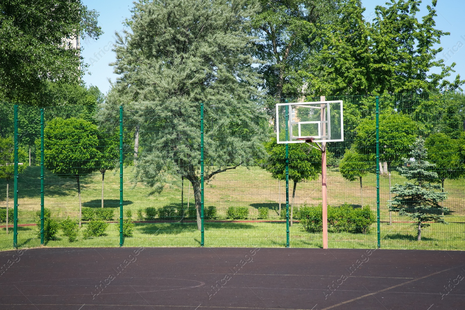 Photo of Empty basketball court outdoors on sunny day