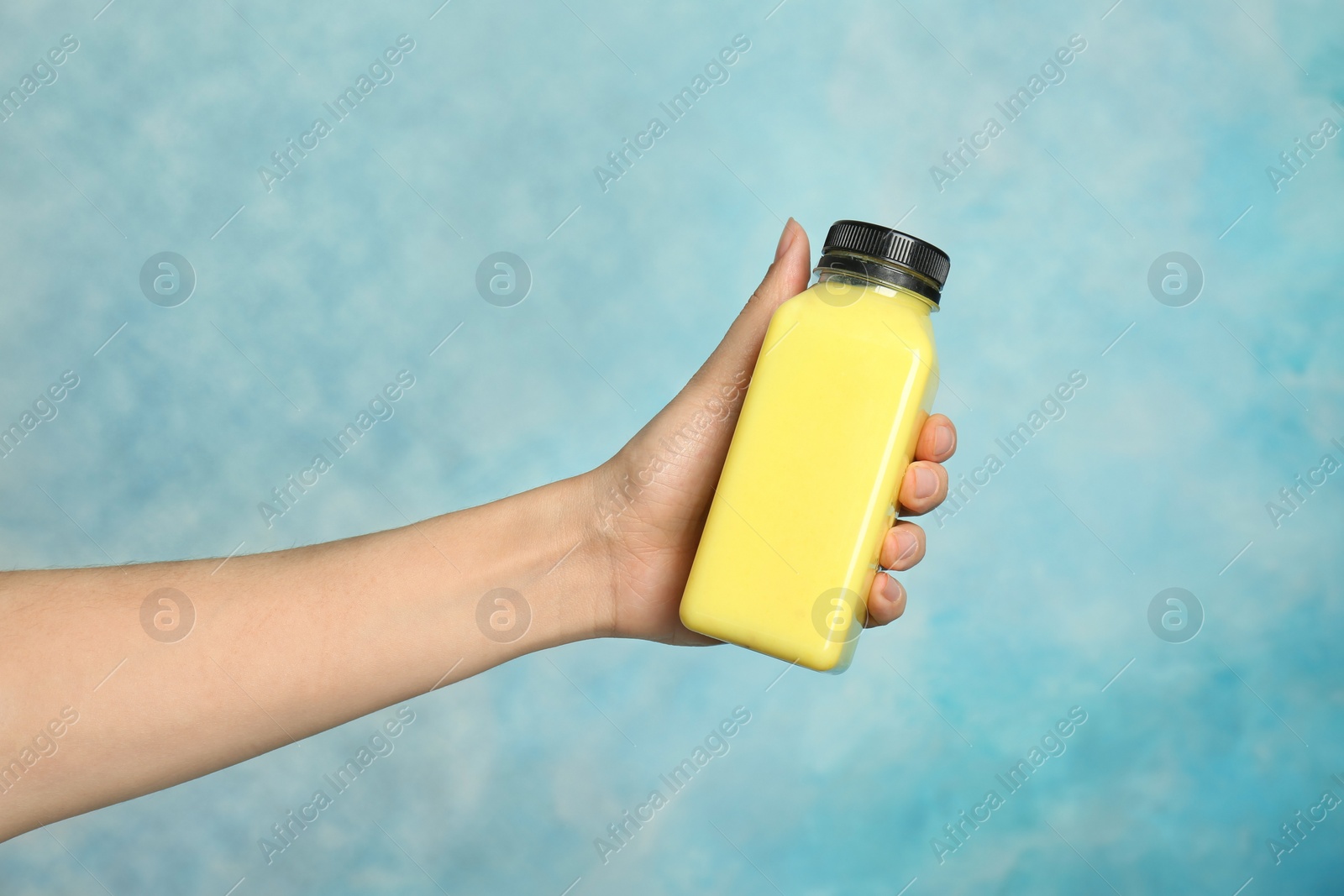 Photo of Woman holding bottle with delicious smoothie on color background