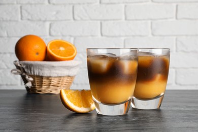 Photo of Tasty refreshing drink with coffee and orange juice on grey marble table