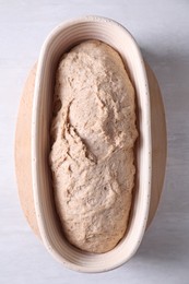 Photo of Fresh sourdough in proofing basket on light table, top view