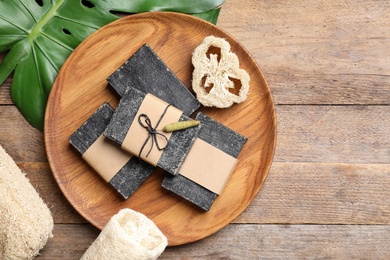 Photo of Natural tar soap on wooden table, flat lay