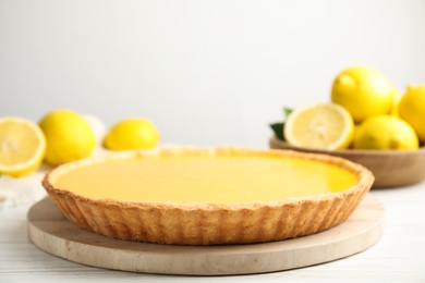 Delicious homemade lemon pie and fresh fruits on white wooden table, space for text