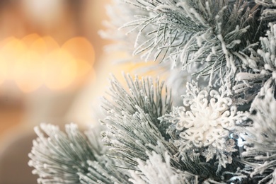 Beautiful decorated Christmas tree  against blurred festive lights, closeup