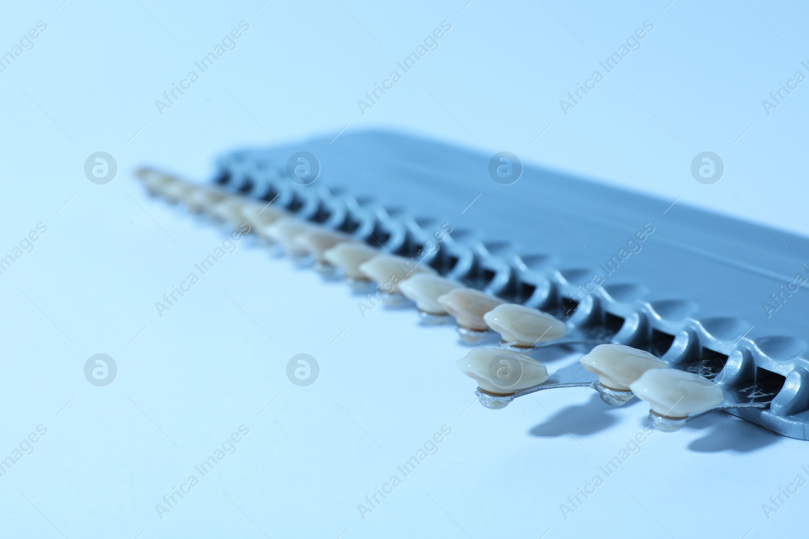 Photo of Teeth shades samples on color background, closeup with space for text. Dentist tools