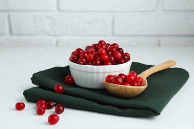 Photo of Cranberries in bowl and spoon on white table