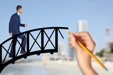 Image of Woman drawing bridge to help businessman walk over. Connection, relationships, support and deal concept