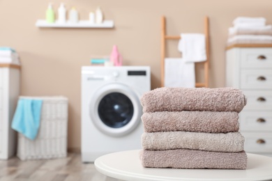 Photo of Stack of towels on table against blurred background, space for text