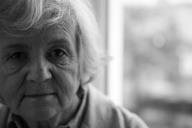Portrait of elderly woman indoors, space for text. Black and white effect