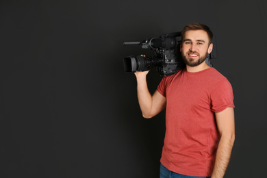 Photo of Operator with professional video camera on black background, space for text