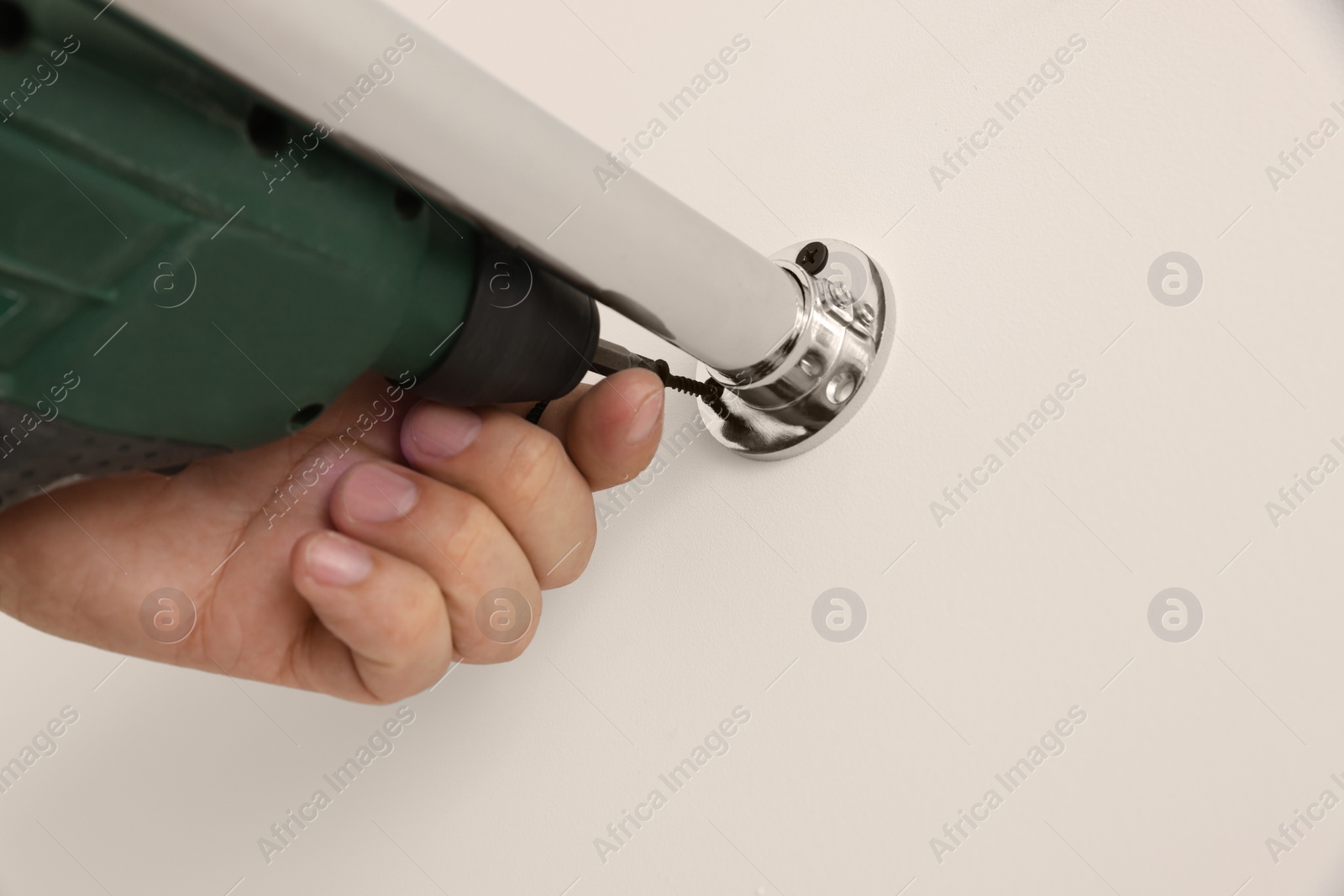 Photo of Worker installing new metal pipes with electric drill, closeup